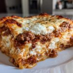 Close-up of a thick, cheesy slice of instant pot lasagna showing layers of meat sauce and ricotta cheese.