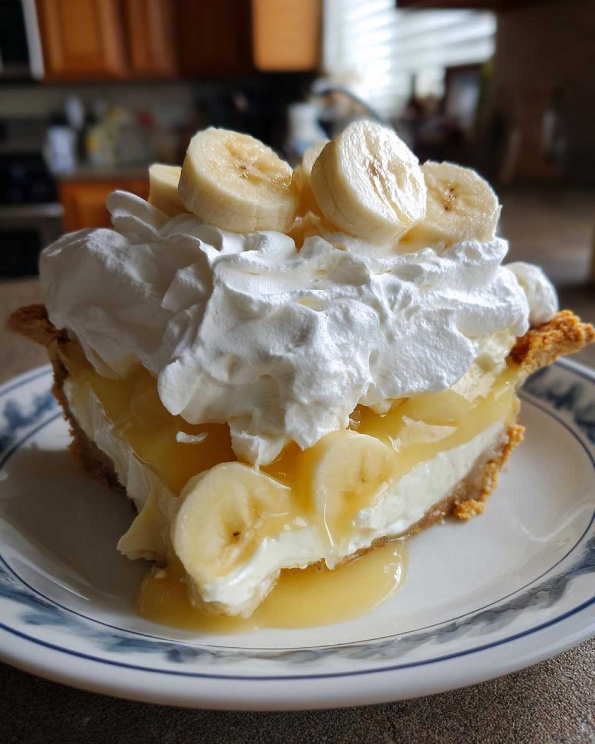 A generous slice of banana cream pie topped with whipped cream and fresh banana slices.
