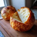 Close-up of a freshly baked bread bowl with the top cut off, revealing the airy interior, perfect for soup.