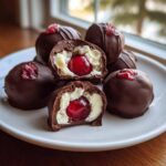 Close-up of homemade chocolate covered cherries, showing the creamy white filling and bright red cherry center.