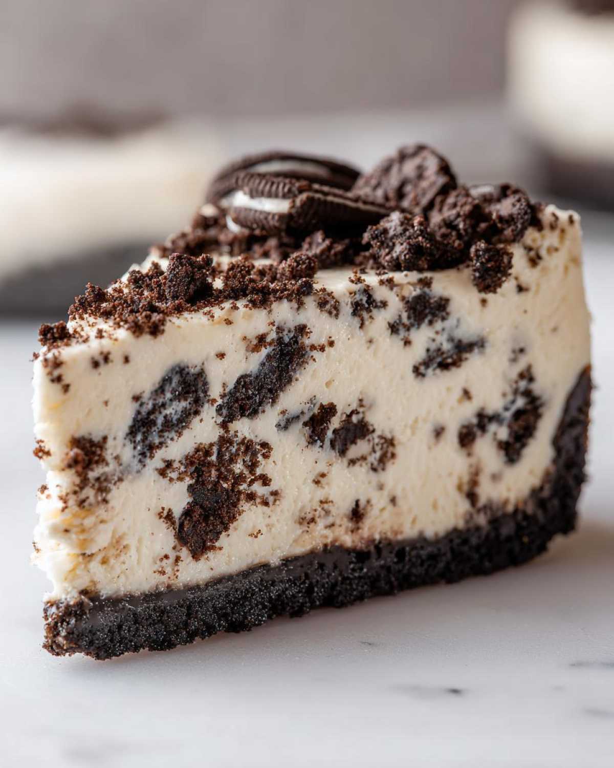 A close-up shot of a perfect slice of Oreo cheesecake with a thick cookie crust and crumbled topping.