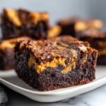 A rich, fudgy square of peanut butter swirl brownies featuring a distinct peanut butter ribbon on top.