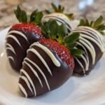 Four beautiful chocolate covered strawberries drizzled with white chocolate, ready to eat.