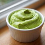 Close-up of thick, vibrant green Copycat Panera Green Goddess Dressing swirled in a white ramekin.
