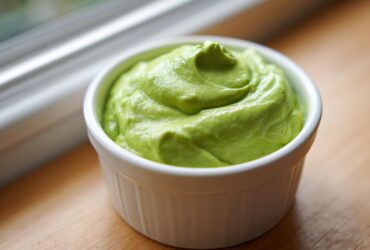Close-up of thick, vibrant green Copycat Panera Green Goddess Dressing swirled in a white ramekin.