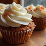 Close-up of moist Gluten-Free Carrot Cake Cupcakes topped with thick cream cheese frosting and shredded carrots.