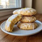 A stack of soft Gluten-Free Lemon Ricotta Cookies topped with a white lemon glaze and zest.