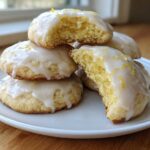 A stack of soft Gluten-Free Lemon Ricotta Cookies topped with a white lemon glaze and zest.