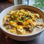 A close-up of a bowl of rich Keto Cheeseburger Soup, featuring ground beef, melted cheddar cheese, and chives.