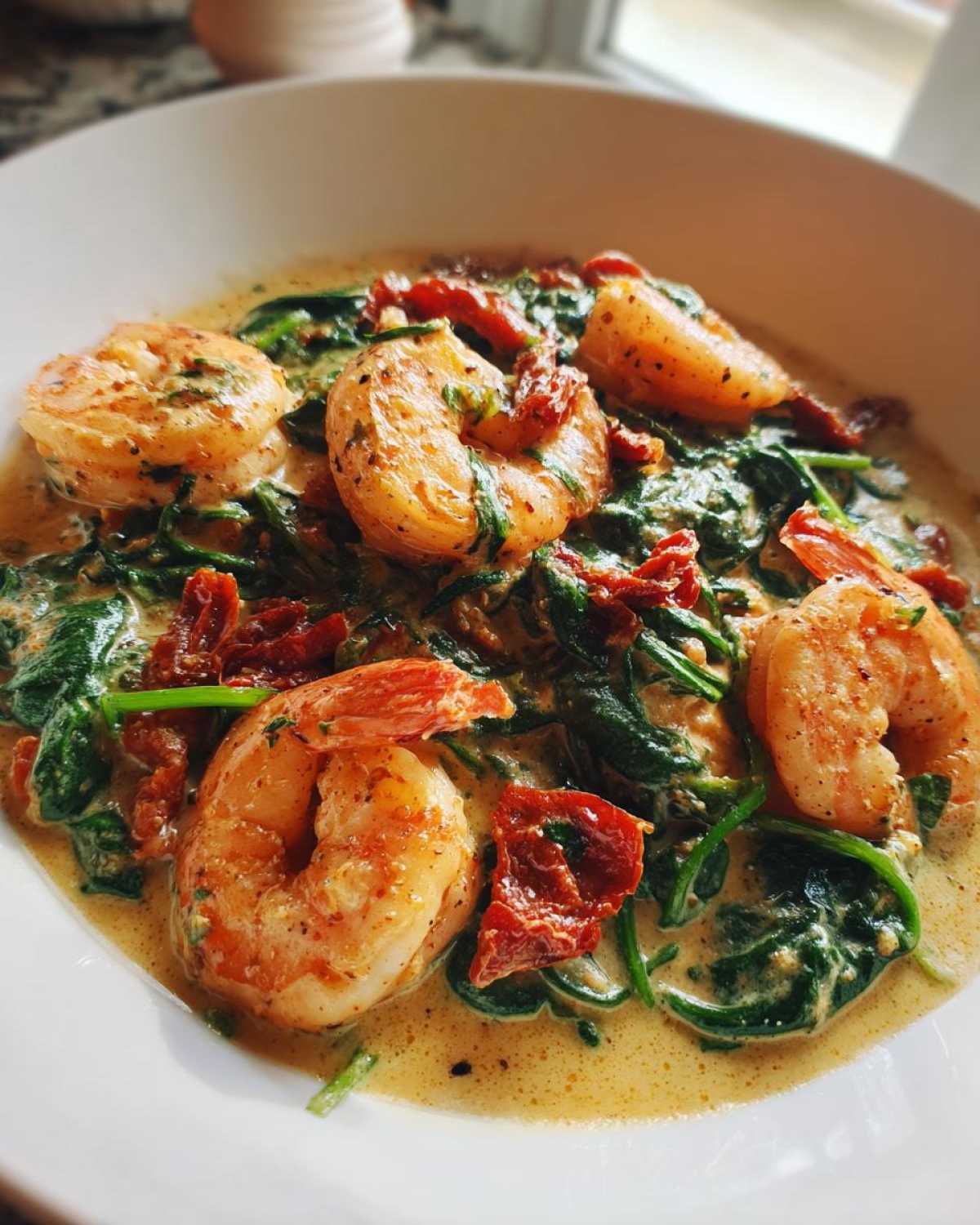 Close-up of Keto Creamy Tuscan Shrimp Skillet featuring plump shrimp, spinach, and sun-dried tomatoes in a rich sauce.