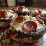 Four baked Keto Pizza Stuffed Portobello Mushrooms topped with melted cheese and pepperoni slices.
