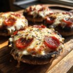 Close-up of baked Keto Pizza Stuffed Portobello Mushrooms topped with melted mozzarella and pepperoni slices.