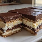 Close-up of layered slices of No-Bake Chocolate Eclair Cake showing graham crackers, creamy filling, and chocolate frosting.