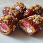 Close-up of No-Bake Strawberry Cheesecake Stuffed Dates, showing the creamy filling and crunchy topping.