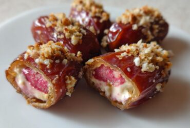 Close-up of No-Bake Strawberry Cheesecake Stuffed Dates, showing the creamy filling and crunchy topping.